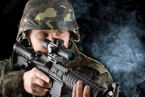Photo: Soldier with the smoking gun. Closeup Soldier with the smoking gun. Closeup