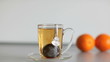 cup of strong black tea biscuit and two orange