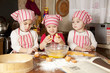 Three little chefs enjoying in the kitchen making big mess. Litt