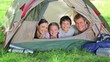 Family smiling while lying in a tent