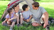 Smiling family sitting on the grass together