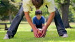 Smiling man playing rugby with his son