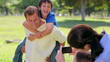 Smiling man giving her son a piggy-back