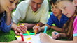Smiling children drawing with their parents