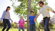 Happy family dancing together on the grass