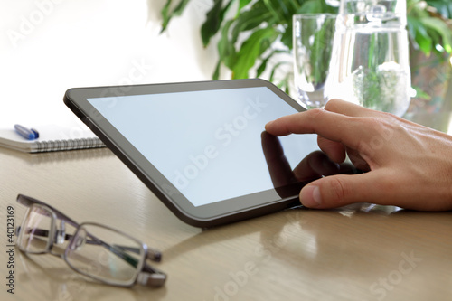 Photo: Finger touching screen of a digital tablet Finger touching screen of a digital tablet
