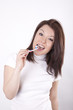 Attractive young woman enjoys cleaning her teeth