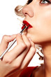 Beautiful blond woman applying makeup on her face