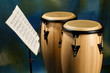 Two congas on colored background with music stand and sheet