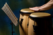 Unrecognizable musician playing congas with music stand