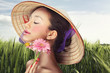 Beautiful Vietnamese girl in a traditional hat is holding flower