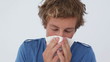 Sick man sneezing into a tissue