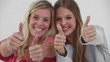 Smiling young women placing their thumbs up