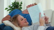 Woman reading a book while her boyfriend is napping