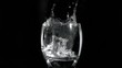 Ice cube falling in super slow motion in a limpid liquid