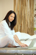 Woman sitting in bed with computer