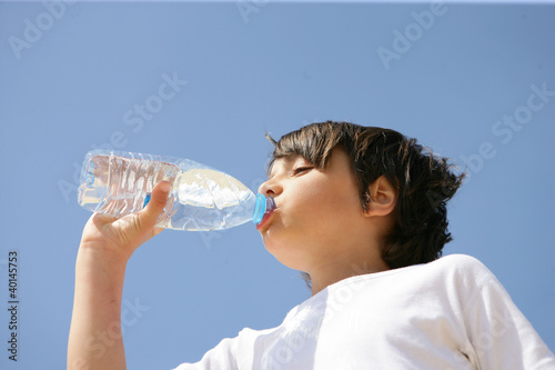 Photo: Little boy drinking from bottle of water Little boy drinking from bottle of water
