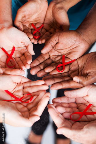 Photo: multiracial people holding red ribbon for AIDS HIV awareness multiracial people holding red ribbon for AIDS HIV awareness