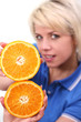 Young woman holding a slice of orange on white background.