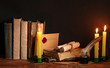 old books, scrolls, feather pen inkwell and candles
