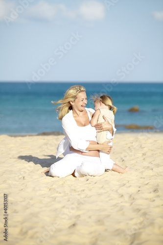 Foto: junge schwangere mutter mit ihrer tochter am strand junge schwangere mutter mit ihrer tochter am strand