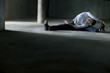 man practicing pilates in dark  concrete urban space