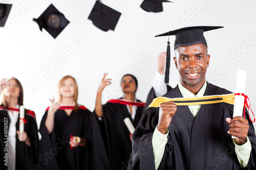 Photo: happy african graduate at graduation with classmates happy african graduate at graduation with classmates