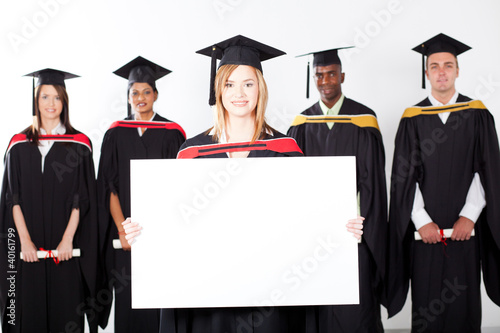 Foto: pretty female graduate holding white board pretty female graduate holding white board