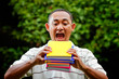 ethnic young man try to eat stack of books ethnic young man try to eat stack of books