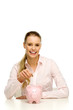 Woman putting money in piggy bank