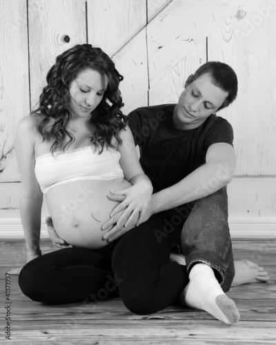 Photo: expectant couple sitting with hands on her bare belly expectant couple sitting with hands on her bare belly