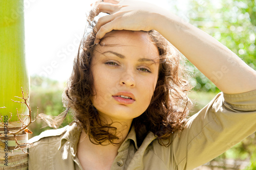 Photo: Pretty woman leaning on palm tree and enjoying freedom and sun Pretty woman leaning on palm tree and enjoying freedom and sun