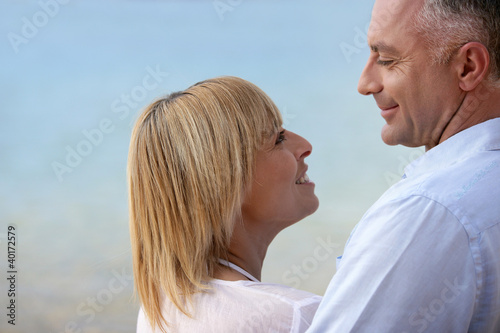 Photo: Mature couple smiling at the seaside Mature couple smiling at the seaside