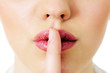 Index finger on woman mouth gesturing silence