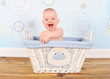 enthusiastic baby boy in blue wicker basket