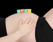 baby spelled out on bare pregnant belly. isolated