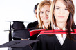 group of female graduates holding graduation caps
