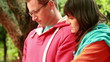 Young couple with tablet computer in the park, steadicam shot