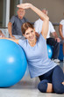 Frau macht Rückenübung mit Gymnastikball