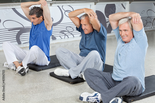 Photo: Männer dehnen sich im Fitnesscenter Männer dehnen sich im Fitnesscenter
