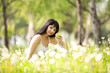 Cute woman eating the apple in the park with dandelions
