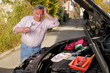Ratloser Senior bei der Autoreparatur