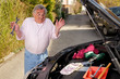Ratloser Senior bei der Autoreparatur