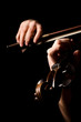 Female hands play a violin on the black