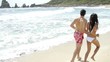 Couple in swimsuit running on the beach