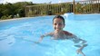 Cheerful woman swimming in private pool
