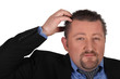 Businessman scratching his head