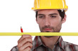 Man in a hardhat with a pencil and measure