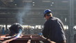 Workers grinding and welding in a factory
