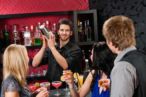 Photo: Barman cocktail shaker friends drinking at bar Barman cocktail shaker friends drinking at bar